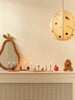 Ferm Living Skye hanglamp brandend in kinderkamer boven kastje met perenspiegel