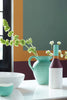 Detailopname van muur geschilderd in Middle Buff 122 met decoratieve accessoires op tafel.