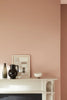 Detail van een schouw met muur in Masquerade van Little Greene – zachte roze tint die warmte en rust brengt in het interieur