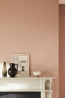 Detail van een schouw met muur in Masquerade van Little Greene – zachte roze tint die warmte en rust brengt in het interieur