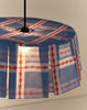 Brandende lampenkap in blauw en rood met zwarte fitting, van dichtbij
