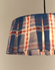 Close-up van geplooide rand van brandende blauw-rode katoenen lampenkap