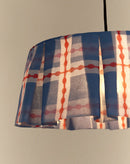 Close-up van geplooide rand van brandende blauw-rode katoenen lampenkap