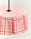 Detail van oudroze lampenkap met crème banden en rode kralenprint
