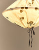 Close-up van onderkant linnen lampion met zwart lintje en doorschijnende stippen